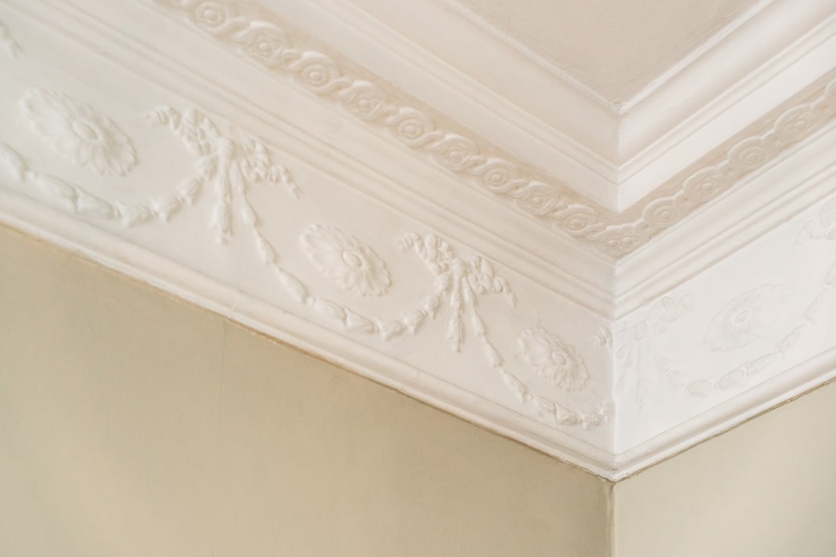 Elegant white decorative plastering on the corner of the ceiling.