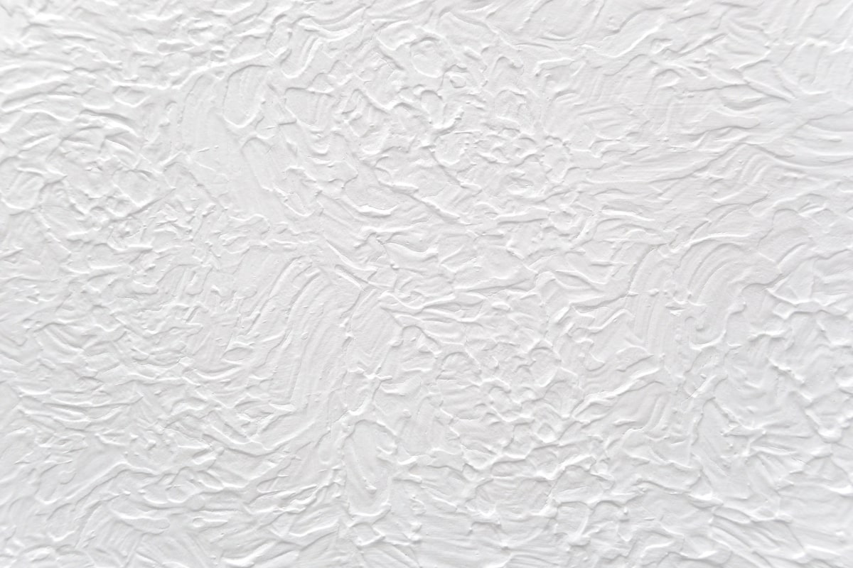Close-up of a white wall featuring textured coating surface.